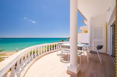 a balcony with a table and chairs and the beach at Beach View Apartment Praia da Luz by Blue Diamond 24-1F in Luz