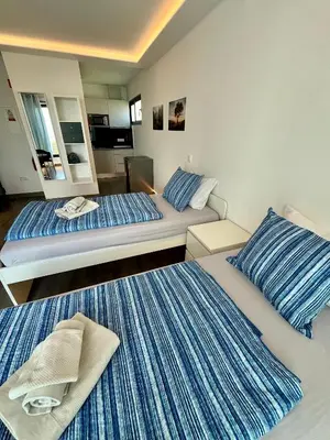 a hotel room with two beds with blue and white stripes at SCIROCCO SUITES Madeira - Ocean View in Água de Pena