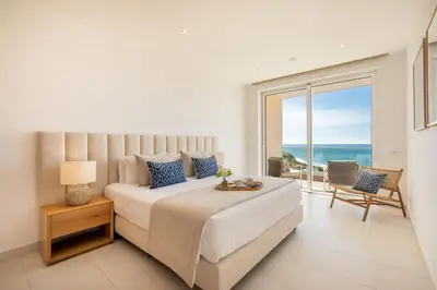 a bedroom with a large bed with a view of the ocean at Beach View Apartment by Blue Diamond 101 in Lagos
