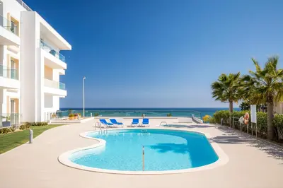a swimming pool in front of a building with the ocean at Beach View Apartment by Blue Diamond 101 in Lagos
