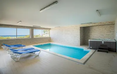 a swimming pool in a room with blue chairs and a table at Beach View Apartment by Blue Diamond 101 in Lagos