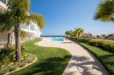a walkway with palm trees and a swimming pool at Beach View Apartment by Blue Diamond 101 in Lagos