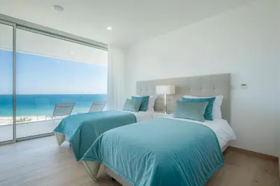 two beds in a bedroom with a view of the ocean at Beach View Villa by Blue Diamond 55 in Lagos