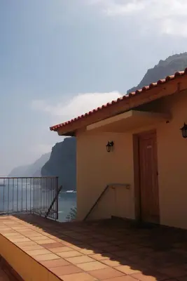 a house with a balcony with a view of the ocean at CASAS MARE , Ponta Delgada, Madeira in Ponta Delgada
