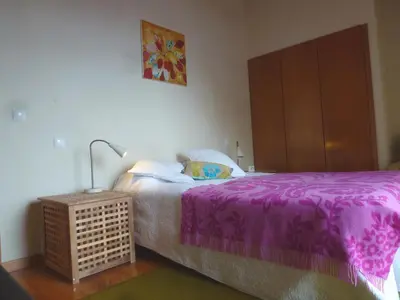 a bedroom with a bed with a purple blanket at CASAS MARE , Ponta Delgada, Madeira in Ponta Delgada
