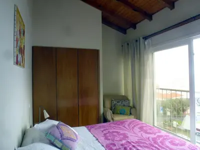 a bedroom with a bed and a large window at CASAS MARE , Ponta Delgada, Madeira in Ponta Delgada