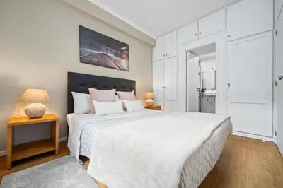 a bedroom with a large white bed and two lamps at Cozy City Center Apartment in Funchal in Funchal