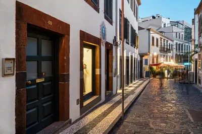 a cobblestone street in an old town at dusk at Cozy City Center Apartment in Funchal in Funchal