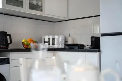 a kitchen with white cabinets and a microwave at Vila Verde in Tábua