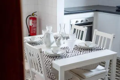 a white dining room table with white chairs and a white table and chairsearcher at Vila Verde in Tábua