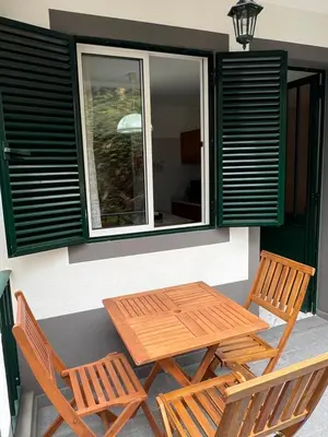 a table and two chairs on a porch with a window at Casa Nova - Maison avec garage, terrasse & Balcon in Ponta do Sol