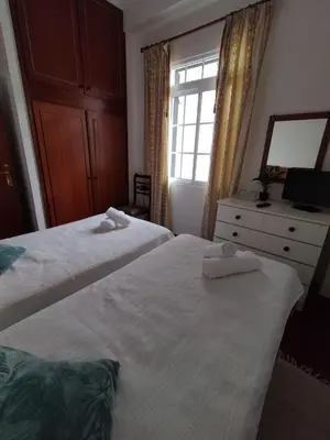 a bedroom with two beds and a dresser and a window at Hortasol A in Funchal