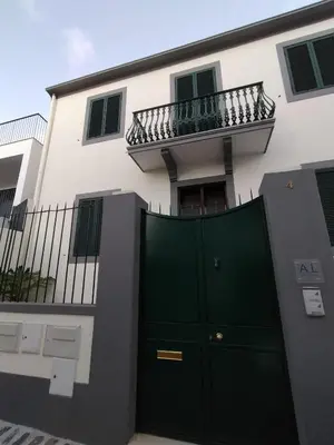 a building with a green door and a balcony at Hortasol A in Funchal