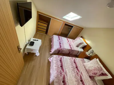 two beds in a small room with a television at Marilu in Santa Cruz