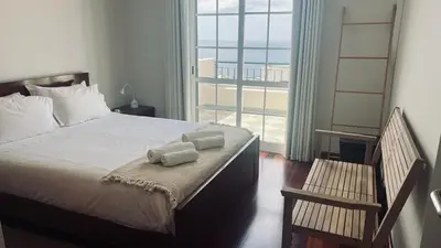 a bedroom with a large bed with a large window at Maribel's Place in Funchal
