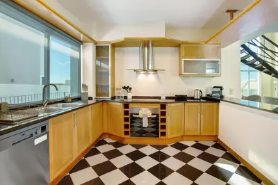 a kitchen with wooden cabinets and a checkered floor at Pico Do Paraíso in Funchal