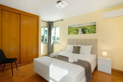 a bedroom with a white bed and a chair at Pico Do Paraíso in Funchal