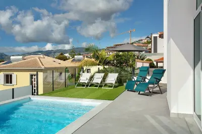 a patio with chairs and a swimming pool at Pico Do Paraíso in Funchal