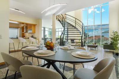 a dining room with a table and chairs and a staircase at Pico Do Paraíso in Funchal