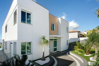 a white house with a palm tree in the driveway at Pico Do Paraíso in Funchal
