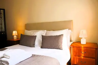 a bedroom with a bed with two lamps on a nightstand at Casa Vicente II, By OP in Boaventura
