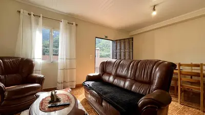 a living room with a leather couch and a table at Casa Vicente II, By OP in Boaventura