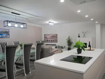 a dining room and living room with a table and chairs at Imperatriz Madeira Apartment in Funchal