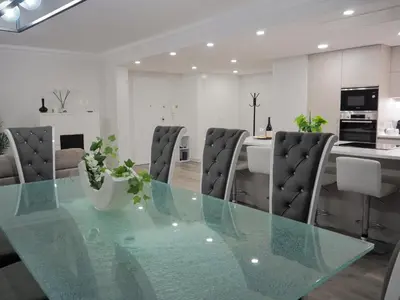 a dining room and kitchen with a glass table and chairs at Imperatriz Madeira Apartment in Funchal