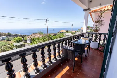 a balcony with a table and a view of the ocean at Sallys in Ponta do Sol