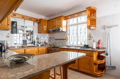 a kitchen with wooden cabinets and a counter top at Sallys in Ponta do Sol