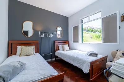 a bedroom with two beds and a window at Sallys in Ponta do Sol