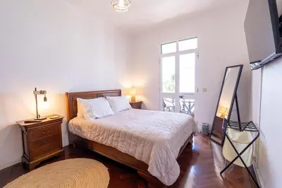 a bedroom with a bed and a dresser and a window at Sallys in Ponta do Sol