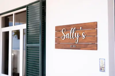 a sign on the door of a building with the word skills at Sallys in Ponta do Sol
