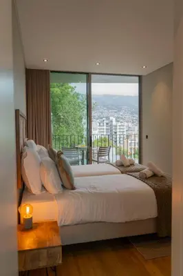 a bedroom with a large bed with a large window at Green Boat by Madeira Best Apartments in Funchal