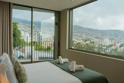 a bedroom with a bed and a large window at Green Boat by Madeira Best Apartments in Funchal