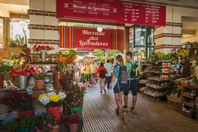 a group of people walking through a flower market at Arriaga Residence I by An Island Apart in Funchal