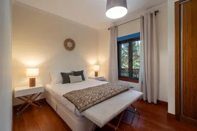 a bedroom with a bed and two lamps and a window at Arriaga Residence I by An Island Apart in Funchal