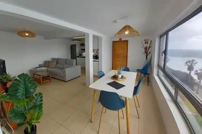 a living room with a table and chairs and the ocean at The Yellow House in Jardim do Mar