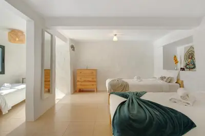 a woman sitting on a bed in a bedroom at The Yellow House in Jardim do Mar