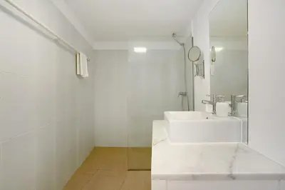 a white bathroom with a sink and a toilet at The Yellow House in Jardim do Mar