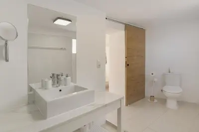 a bedroom with a white bed with a red dress on it at The Yellow House in Jardim do Mar