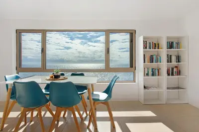 a dining room with a table and chairs and a window at The Yellow House in Jardim do Mar