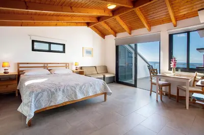 a table and chairs with a potted plant on a balcony at The Wave House - Oceanfront in Jardim do Mar