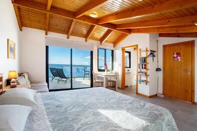 a bedroom with a bed and a view of the ocean at The Wave House - Oceanfront in Jardim do Mar