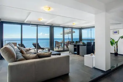 a living room with a couch and a view of the ocean at The Wave House - Seaside Haven in Jardim do Mar