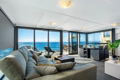 a living room with a large couch and views of the ocean at The Wave House - Seaside Haven in Jardim do Mar