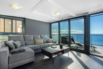 a living room with a couch and a view of the ocean at The Wave House - Seaside Haven in Jardim do Mar