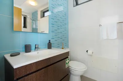 a bathroom with a sink and a toilet and a mirror at Original Wave House in Jardim do Mar