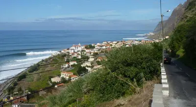 a town on a hill next to the ocean at Original Wave House in Jardim do Mar