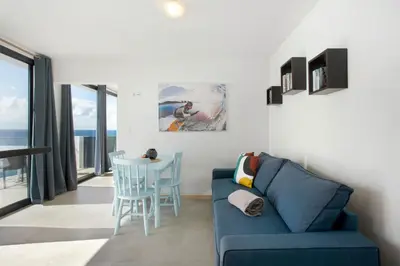 a living room with a blue couch and a table at Original Wave House in Jardim do Mar